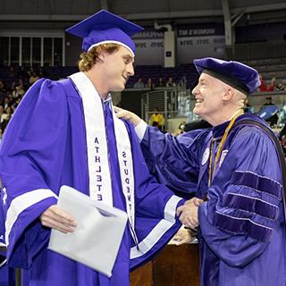 Max Duggan shaking hands with Chancellor Boschini at graduation